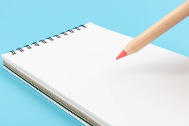 Kalemler ve boş defterler mavi arkaplanda kopyalama alanı ile