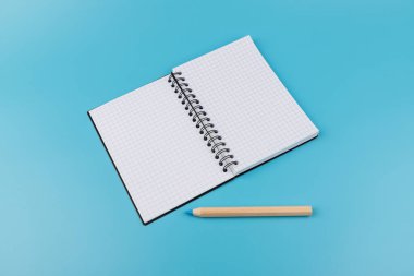 Kalemler ve boş defterler mavi arkaplanda kopyalama alanı ile