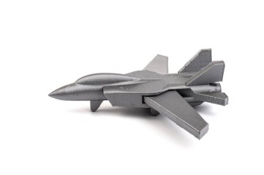 Beyaz arkaplanda 3 boyutlu bir yazıcıda üretilen gri model bir savaş uçağı. ulaşım kavramı