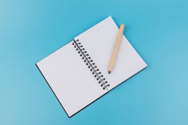 Kalemler ve boş defterler mavi arkaplanda kopyalama alanı ile