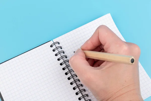 Hand Mit Bleistift Notizbuch Isoliert Über Blauem Hintergrund — Stockfoto