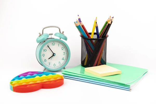 闹钟上有笔记本和蜡笔 概念上有文字或其他内容的空间 内容涉及小学的学校和时间管理 — 图库照片