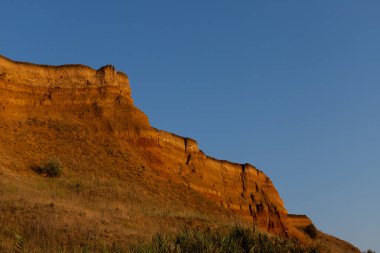 Güzel manzara, denizin üzerindeki kumlu uçurum. Seyahat konsepti. Güzel doğa dokusu