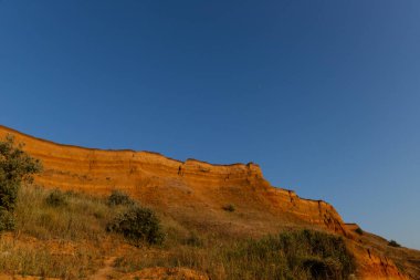 Güzel manzara, denizin üzerindeki kumlu uçurum. Seyahat konsepti. Güzel doğa dokusu