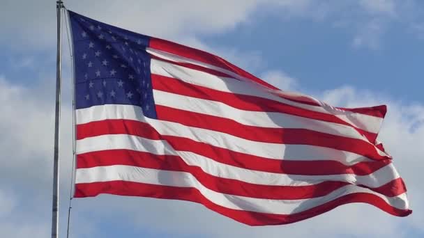 Bandera estadounidense en un asta de la bandera ondeando en el viento — Vídeos de Stock