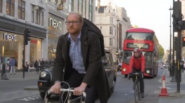 Londra 'da kırmızı otobüsler ve taksilerle dolu bir cadde.