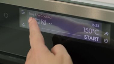 Kadın programı elektrikli fırına koyuyor..