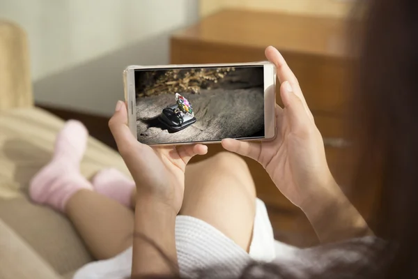 Güzel bir kadın telefon yatakta mutlu sabah oynarken. O lik