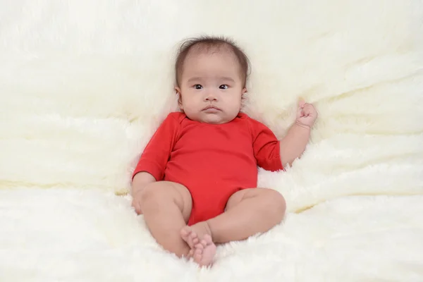 Asiático bonito bebê sentado em um pano macio na sala de estar . — Fotografia de Stock