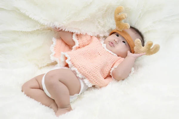 Bebê sentado em um pano macio na sala de estar — Fotografia de Stock