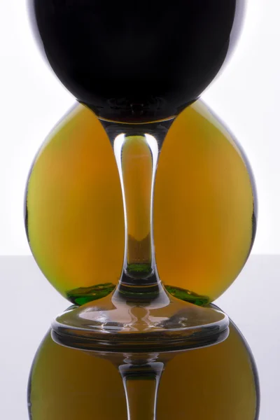 Glas mit Wein gegen runde Flasche — Stockfoto