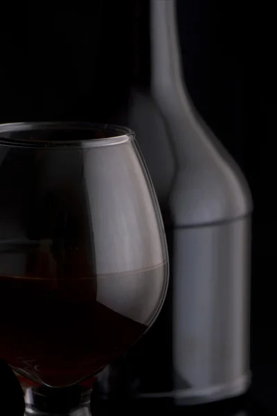 Коньячное стекло с бутылкой — стоковое фото