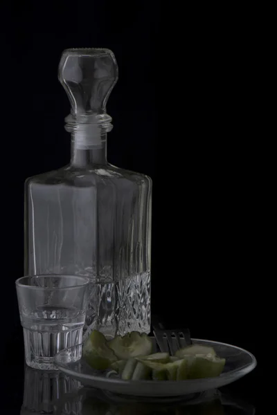 Vodka, pepinos, vaso de chupito sobre fondo negro — Foto de Stock