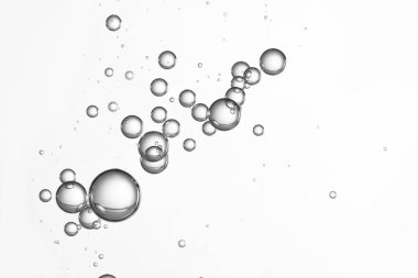 Gümüş renkli parlak su kabarcıkları bir bardakta akıyor..