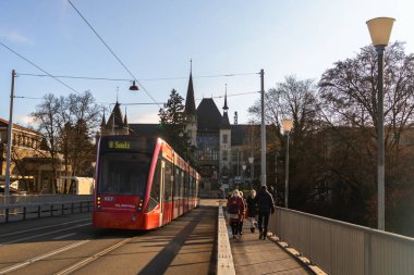 Bern kızıl tramvayı, İsviçre 'de güneşli bir günde Einstein müzesi ve köprünün üzerinden geçiyor.