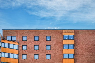 Çağdaş inşaat cephesinin üst kısmının tuğla duvarı. Bina günümüzde, turuncu tuğlalardan ya da pencerelerden oluşan ve balkonlarla kaplı yangın tuğlalarından oluşan modern dairelerden oluşuyor. Malmö, İsveç