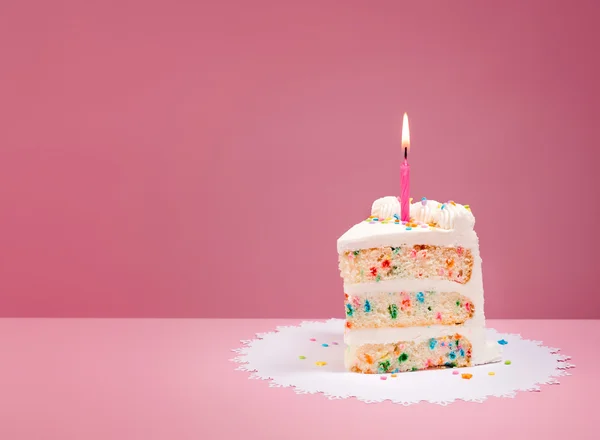 Fetta di torta di compleanno con candela su rosa Immagine Stock