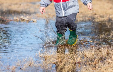 Boy Playing in Puddles clipart