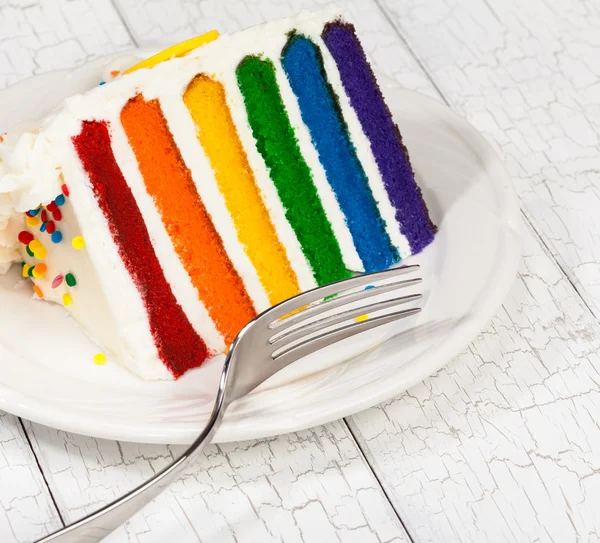 Rebanada de pastel de cumpleaños en capas de arco iris colorido —  Fotos de Stock