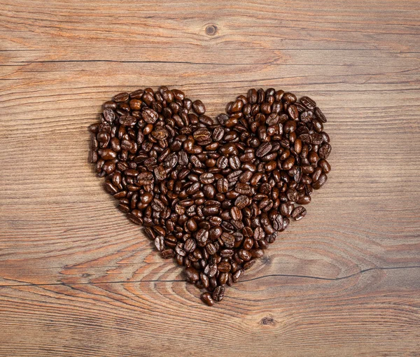 Grãos de café dispostos em forma de coração — Fotografia de Stock