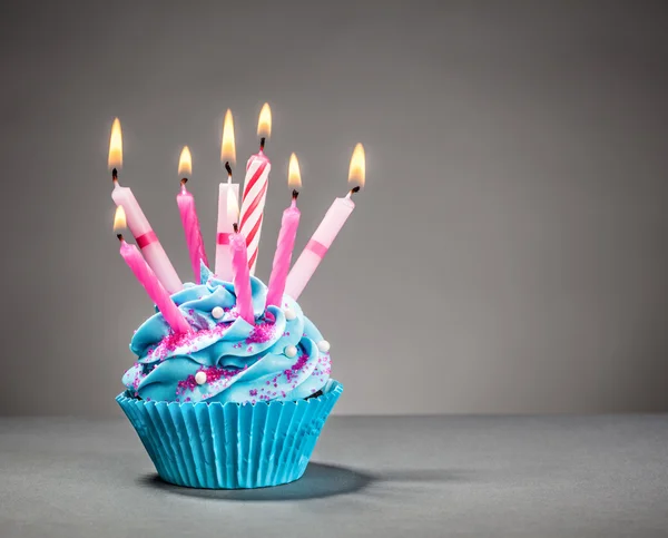 Narozeniny Cupcake s modrou polevou a růžové svíčky — Stock fotografie