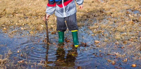 水たまりで遊んでいる少年 — ストック写真