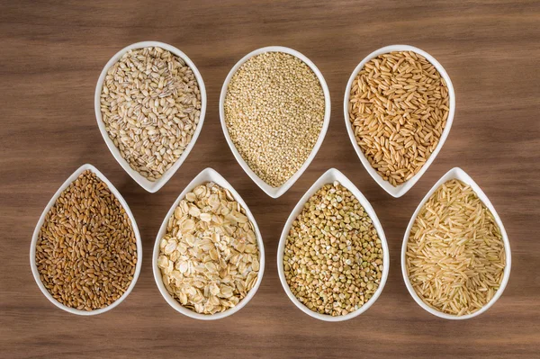 Un assortimento di cereali integrali in ciotole Immagine Stock