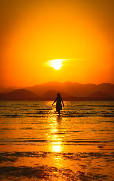 Silhouette eines Mädchens am Strand bei Sonnenuntergang. — Stockfoto