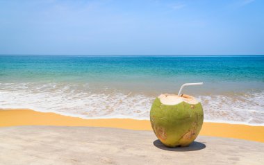 Hindistan cevizi suyu ahşap masa ve güzel bir plaj arka plan. Kopya alanı