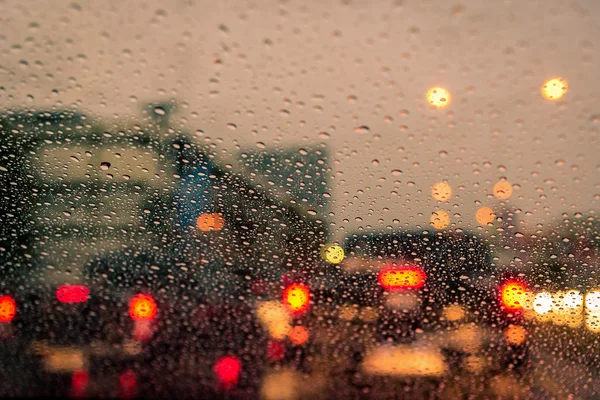 Lluvia cae en la ventana con semáforo. Enfoque selectivo — Foto de Stock