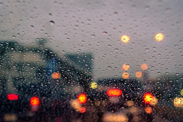 Lluvia cae en la ventana con semáforo. Enfoque selectivo — Foto de Stock