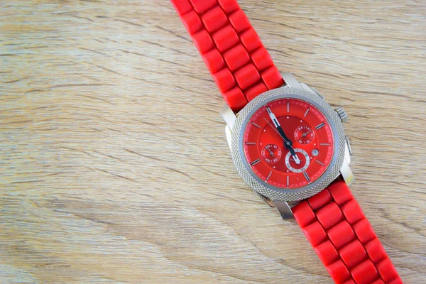 Reloj de pulsera rojo sobre mesa de madera —  Fotos de Stock