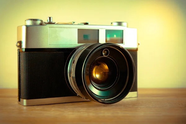 Retro camera on wooden table background. Vintage color tone — Stock Photo, Image