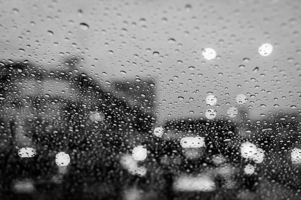 Negro ans lluvia blanca cae en la ventana con semáforo. Enfoque selectivo — Foto de Stock