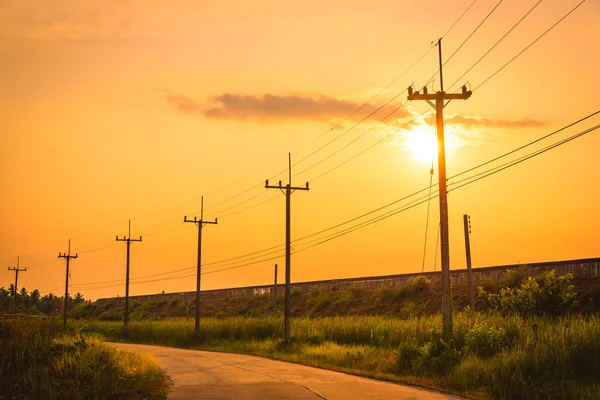 Θέση ηλεκτρικής ενέργειας σιλουέτα με όμορφο ηλιοβασίλεμα φόντο. — Φωτογραφία Αρχείου