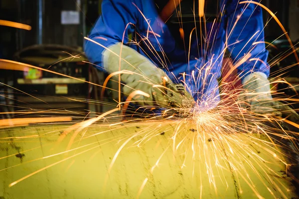 Rectificadora en acción con chispas brillantes en fábrica de construcción — Foto de Stock