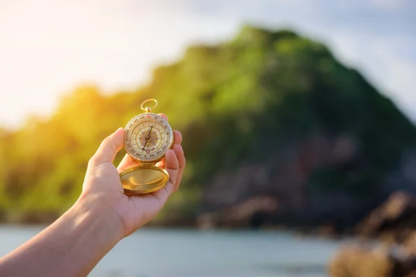 Compass in the hand on the nature background. — Stock Photo, Image