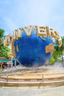 Singapur - 9 Temmuz: Turist ve Universal Studios önünde büyük dönen küre çeşme 9 Temmuz 2014 Sentosa Island, Singapur fotoğraflarını Tema parkı ziyaret edenler