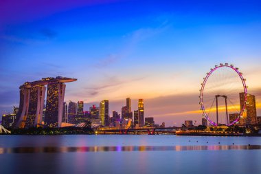Singapur'da alacakaranlık saatinde gökdelenlerin silueti ve görünümü.