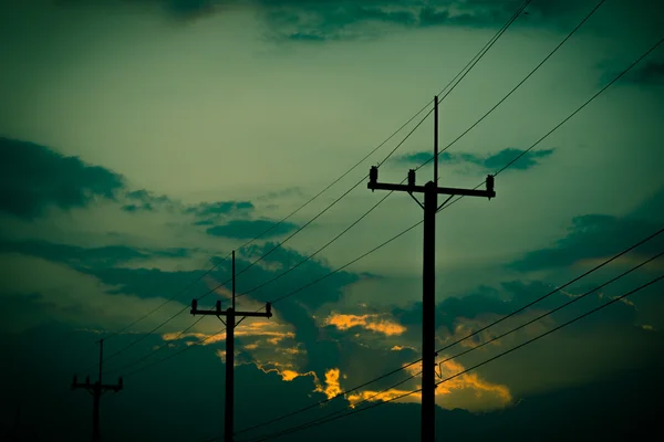 Sziluettjét villamosenergia post gyönyörű naplemente háttérrel. Vintage hang — Stock Fotó