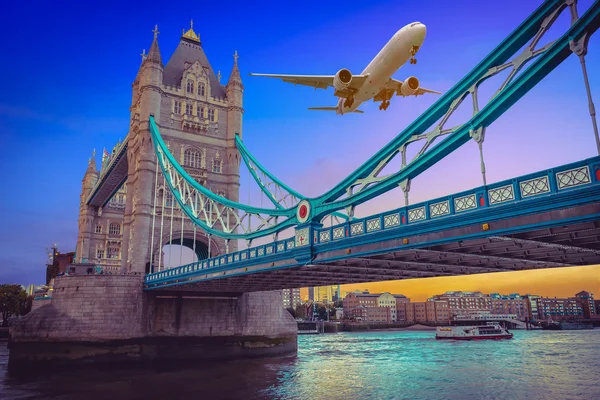 Letadlo letící nad Tower Bridge při západu slunce v Londýně, Velká Británie. — Stock fotografie