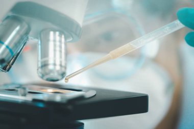 Doktor ya da bilim adamı, tıbbi araştırma laboratuarına ya da bilim laboratuarına numune bırakmak için pipette kullanıyor.