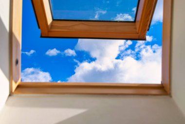 Looking up to the blue cloudy sky through modern square window. Selective blue sky