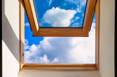 Looking up to the blue cloudy sky through modern square window