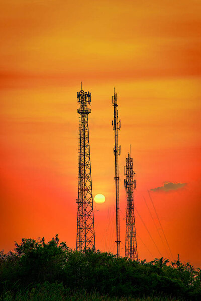 Silhouette telecommunications antenna for mobile phone at sunset