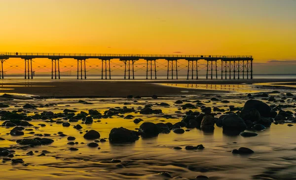 Coucher de soleil sur la côte de Saltburn à l'aube avec des rochers au premier plan — Photo