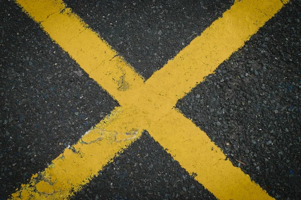 Желтый x знак пересечения дороги окрашен в асфальт — стоковое фото