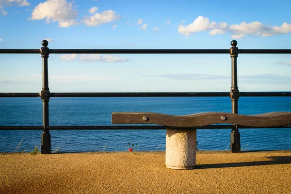 Banco de madeira com o olhar para o mar azul — Fotografia de Stock