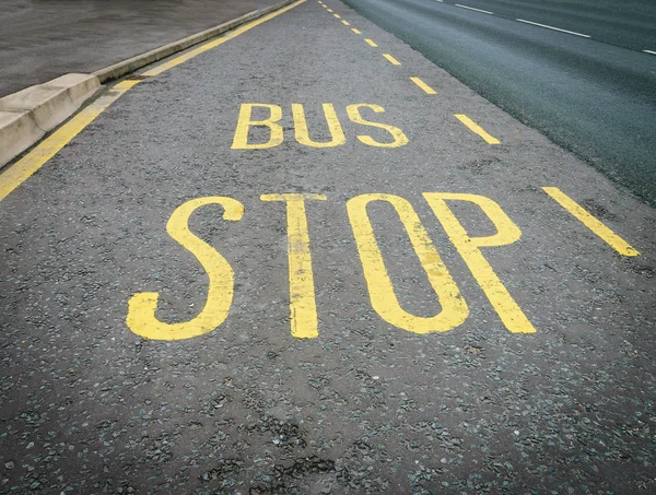 Желтый знак остановки автобуса окрашен на дорожном асфальте — стоковое фото