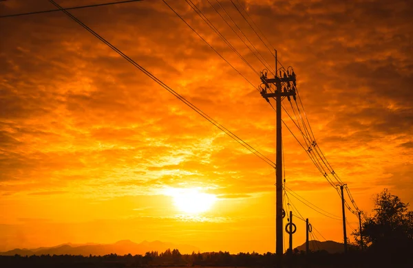 Silhouette electricity post with beautiful sunset background. — Stock Photo, Image